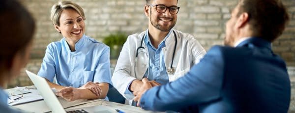 group-healthcare-workers-greeting-financial-advisor-meeting-office-focus-is-young-doctor-scaled-rkxka7g4iys32w5n93mljpkbry4ugif3ae38s3r0n0