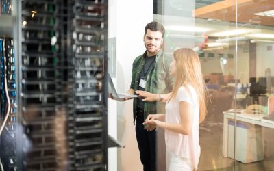two-business-people-standing-server-room-with-laptop-discussing-2048x1365